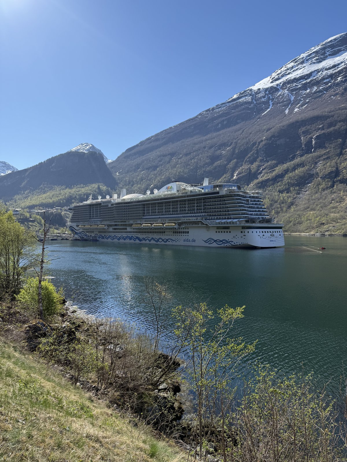 Die AIDA Nova im Geirangerfjord vor schneebedeckten Bergen